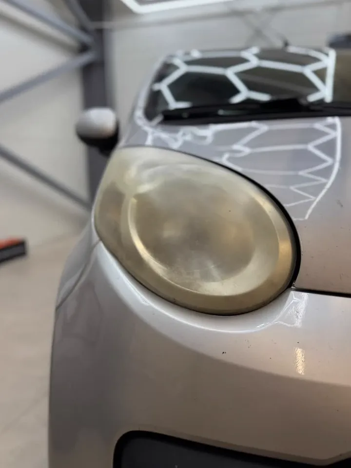 Pożółkły, matowy reflektor Citroëna przed polerowaniem