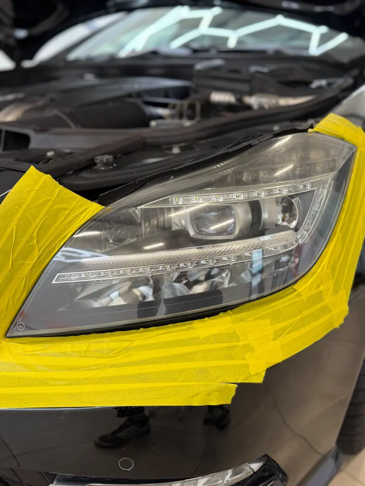 Reflektor Mercedesa zabezpieczony taśmą przed polerowaniem